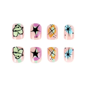 Detail of pink press-on nails featuring Y2K heart patterns and colorful abstract designs