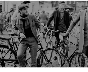 Classic British style newsboy cap and wool scarf on a gentleman with a retro bicycle