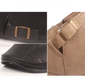 Detail of vintage PU leather flat cap showing bronze buckle and dual stitching lines