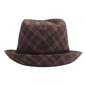 Détail macro du chapeau fedora à carreaux marron avec ruban décoratif noir sur fond blanc