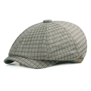 Detail of grey houndstooth newsboy cap with vintage texture and leather side label