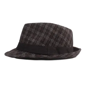 Détail du motif à carreaux foncés et du ruban noir sur un chapeau fedora rétro