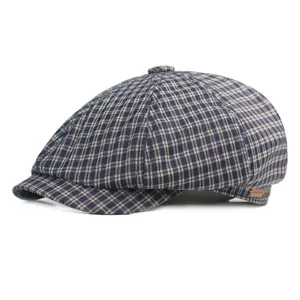 Close-up of classic plaid newsboy cap texture with a decorative brown leather side label