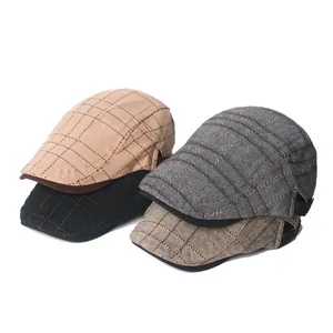 Detail von vier Retro-Schiebermützen in Khaki, Schwarz und Grau mit kariertem Muster