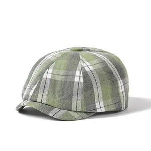 Close-up of green plaid newsboy cap showing woven texture and top button detail
