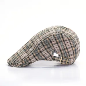 Close-up of vintage plaid beret showing the bronze adjustable buckle and fabric texture