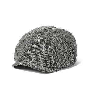 Detail view of the herringbone wool texture and top button on a retro newsboy cap