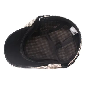Detail view of cotton plaid beret interior showing 100% cotton label and black lining