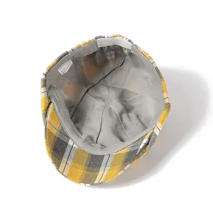 Detailed interior of plaid newsboy cap showing grey lining and 100% polyester wash label