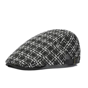 Détail d'une casquette plate à carreaux montrant la texture tweed et l'attache réglable
