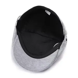 Detailed interior view of grey wool flat cap showing black lining and care label info