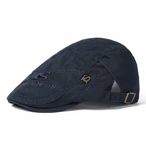 Détail de la boucle en métal réglable et broderie en coton marine sur la casquette plate