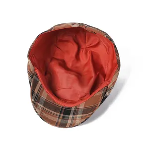 Detail of plaid beret hat with classic check pattern and bright red fabric lining