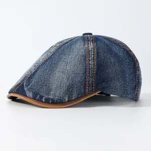 Vintage washed denim beret with orange stitching and brown leather brim, side view