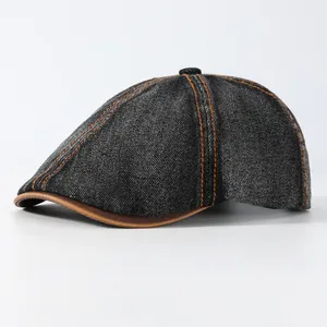 Vintage washed denim newsboy cap in dark grey with orange contrast stitching and faux leather brim