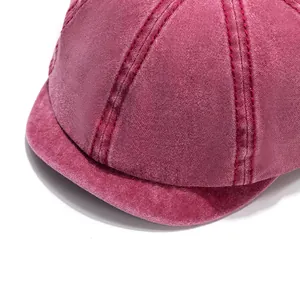 Detail of washed cotton baker boy hat showing burgundy canvas texture and double stitching
