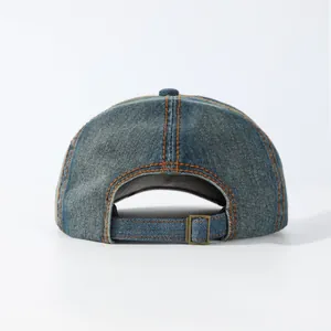 Detail of washed denim baseball cap back with orange stitching and metal buckle