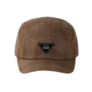 Short brim 5-panel camping cap in dark brown canvas fabric with a triangular logo patch