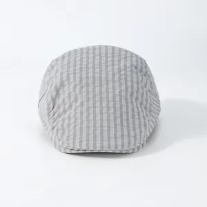 Detailopname van grijze geruite platte pet met focus op vintage patroon en textuur