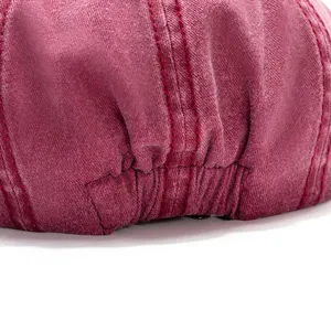 Detail of burgundy cotton newsboy cap showing elastic back band and quality red stitching