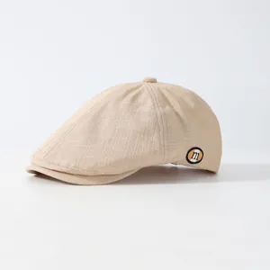 Casquette gavroche beige avec texture lin et petit badge 'm' vue de face à 45 degrés