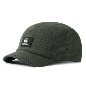 Vue détaillée du chapeau de camping à carreaux verts avec patch logo et œillets métalliques