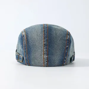 Detail van blauwe denim platte pet met contrasterende stiksels en verstelbare metalen gesp