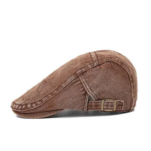 Detail of vintage dark brown denim flat cap with adjustable copper buckle and stitching