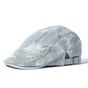 Vintage light blue washed denim newsboy cap with adjustable metal buckle on white background