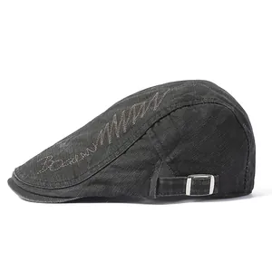 Detail view of cotton flat cap featuring metal buckle and side embroidery texture