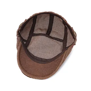 Detailed interior of a brown newsboy cap featuring fabric lining and metal side buckles