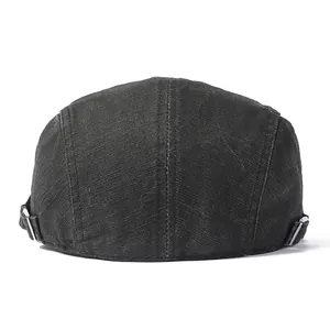 Detail view of the black cotton flat cap with an adjustable metal buckle on the back