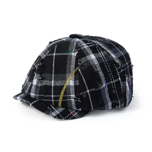 Casquette gavroche à carreaux noir et blanc avec détails usés et coutures graffiti colorées