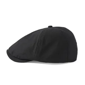 Détail d'une casquette gavroche noire montrant la texture sergée et la visière courte