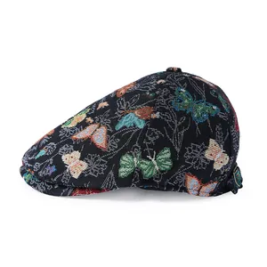 Close-up of black jacquard flat cap with colorful butterfly pattern and woven texture
