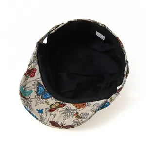 Detail view of ethnic butterfly embroidery fabric and interior lining of the beret hat