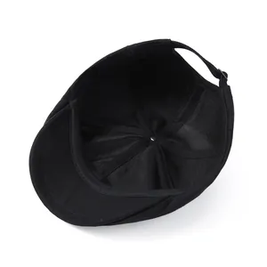 Détail intérieur d'un béret noir montrant les coutures et la boucle de réglage en métal