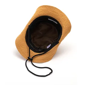 Detail of waterproof ginger yellow hiking hat featuring breathable black mesh lining