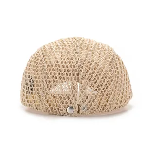 Détail du béret en maille beige avec tricot ajouré respirant et bouton pression en métal