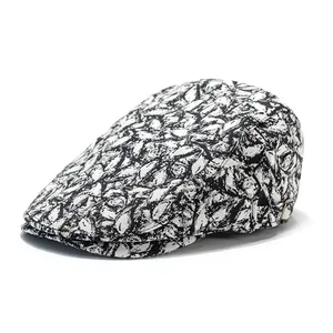 Detail of black and white abstract textured fabric and metal buckle on newsboy cap