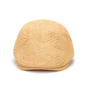 Détail d'une casquette plate en paille marron clair avec texture tissée et surpiqûres