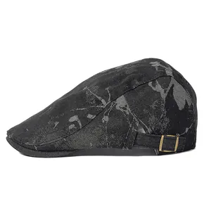 Dettaglio di un berretto piatto vintage nero con stampe graffiti e fibbia in bronzo