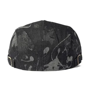 Dettaglio del berretto docker nero in cotone con stampa graffiti e fibbie metalliche