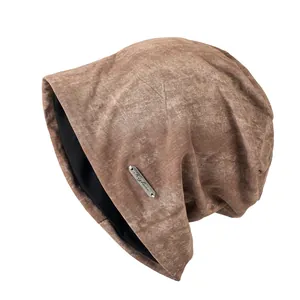 Bruine slouchy gebreide muts in vintage stijl met een metalen merkplaatje
