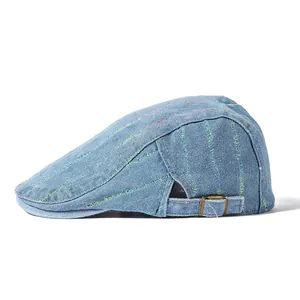 Détail du béret en jean bleu avec coutures colorées et boucle métallique réglable