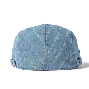 Détail d'un béret en jean bleu avec coutures en V colorées et boucle en métal