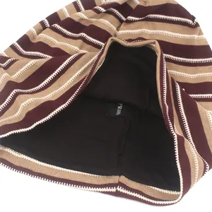 Detalle del gorro de punto a rayas mostrando el forro negro interior y etiqueta de lavado