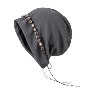 Bonnet slouchy gris en maille pour femme avec étoiles en bois et détails à franges