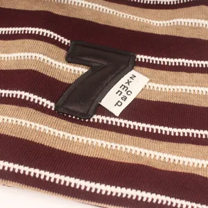 Primer plano de gorro de punto a rayas con parche de cuero número 7 y etiqueta pequeña