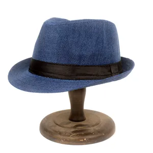 Détail d'un chapeau fedora tressé bleu marine avec ruban noir sur un support en bois